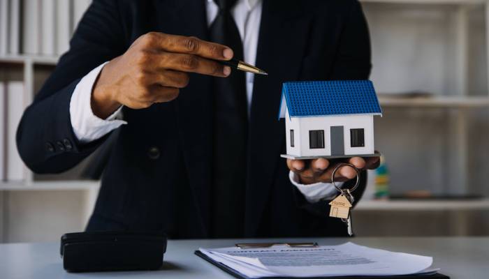 House model with real estate agent and customer discussing for contract to buy house, insurance or loan real estate background.
