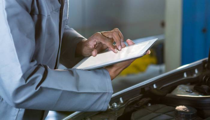 Mechanic using digital tablet at repair garage