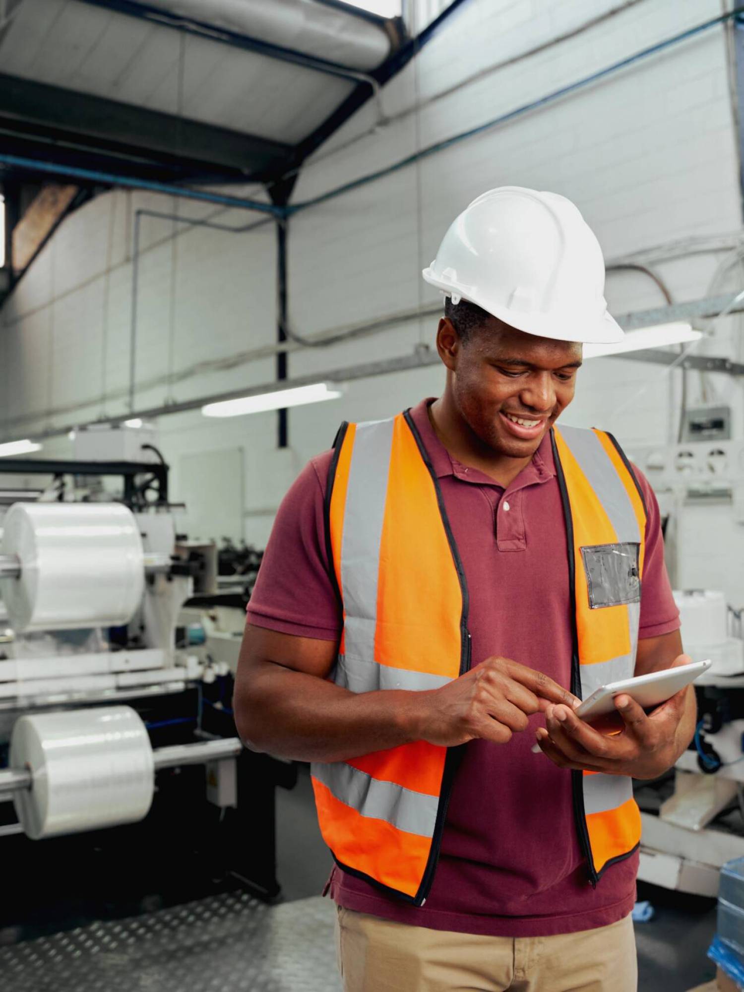 smiling-young-african-male-employee-using-digital-tablet-while-working-industry-red